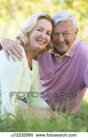 Couple relaxing in park smiling View Large Photo Image Stock Photography - Couple relaxing in park smiling. Fotosearch