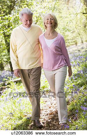 Couple walking outdoors smiling View Large Photo Image Stock Photograph - Couple walking outdoors smiling. Fotosearch