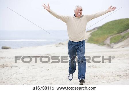 Stock Photography - Man at the beach running and smiling. Fotosearch