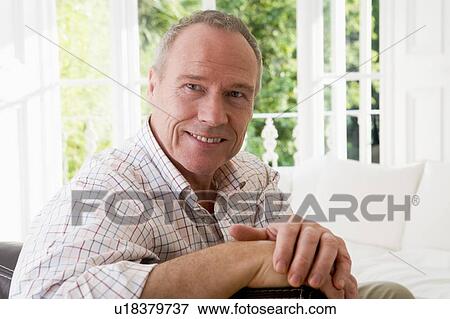 Stock Photo - Man in living room smiling. Fotosearch