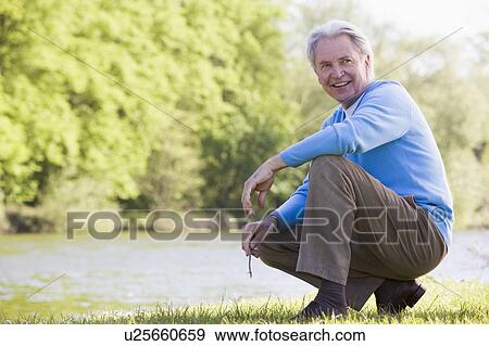 Man outdoors at park by lake smiling View Large Photo Image Stock Photo - Man outdoors at park by lake smiling. Fotosearch
