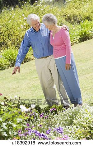 Stock Photo - Senior couple in a flower garden. Fotosearch