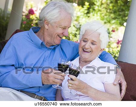 Senior couple sitting outdoors having a glass of red wine View Large Photo Image Stock Image - Senior couple sitting outdoors having a glass of red wine. Fotosearch