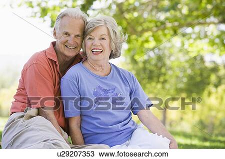 Stock Image - Senior couple sitting outdoors. Fotosearch