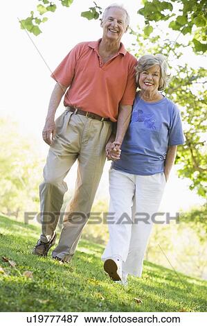 Senior couple walking in park together View Large Photo Image Stock Photo - Senior couple walking in park together. Fotosearch