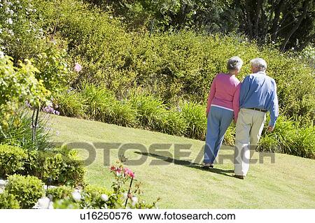 Stock Photograph - Senior couple walking through a flower garden. Fotosearch
