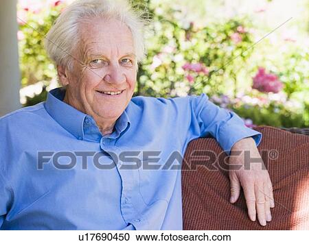 Stock Image - Senior man sitting outdoors. Fotosearch