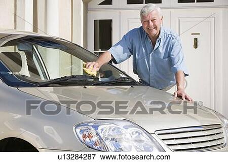 Stock Photo - Senior man washing his car outside his home. Fotosearch