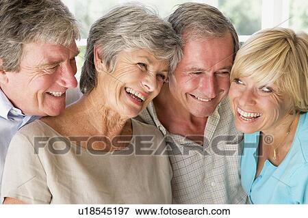 Stock Photo - Two couples indoors smiling. Fotosearch