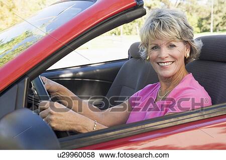 Stock Photo - Woman in convertible car smiling. Fotosearch
