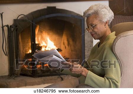 Woman in living room reading newspaper View Large Photo Image Stock Photography - Woman in living room reading newspaper. Fotosearch