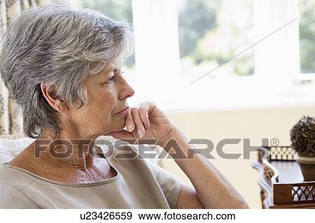 Woman in living room thinking View Large Photo Image Stock Photo - Woman in living room thinking. Fotosearch