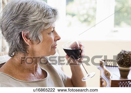 Woman in living room with glass of wine View Large Photo Image Stock Image - Woman in living room with glass of wine. Fotosearch
