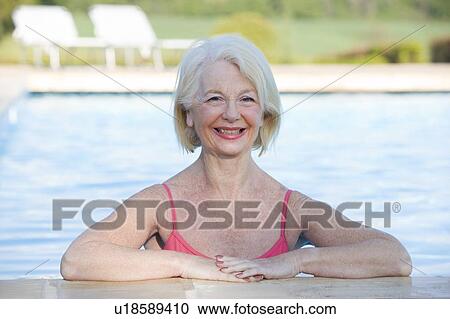 Stock Image - Woman in outdoor pool smiling. Fotosearch