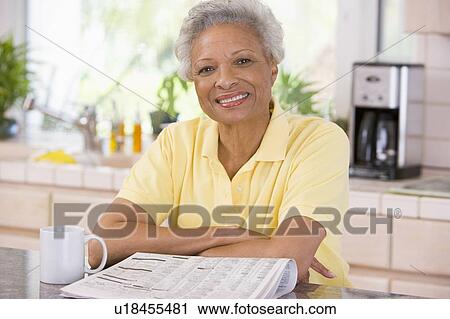 Stock Image - Woman with a newspaper smiling. Fotosearch