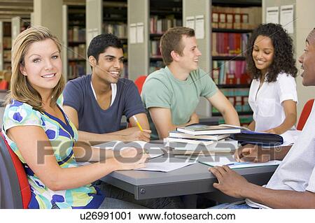 Stock Image - Five people in library studying (selective focus). Fotosearch
