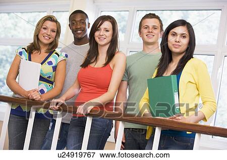 Stock Photo - Five students in corridor leaning on railing with notebooks. Fotosearch