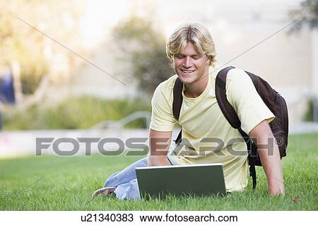 Man outdoors sitting on grass with laptop (selective focus) View Large Photo Image Stock Image - Man outdoors sitting on grass with laptop (selective focus). Fotosearch