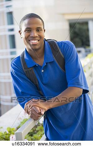 Man standing on balcony leaning on railing (selective focus) View Large Photo Image Stock Image - Man standing on balcony leaning on railing (selective focus). Fotosearch
