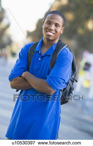 Stock Photo - Man standing outdoors smiling (selective focus). Fotosearch