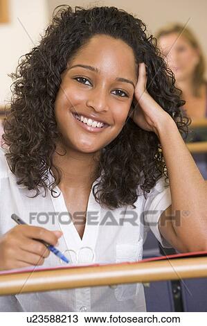 Stock Image - Student in class taking notes (selective focus). Fotosearch