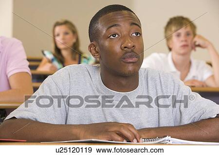 Stock Photo - Student in class taking notes (selective focus). Fotosearch
