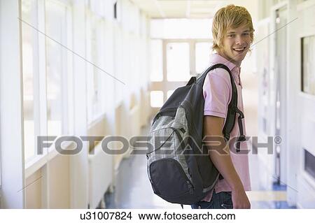 Picture - Student standing in corridor (selective focus). Fotosearch