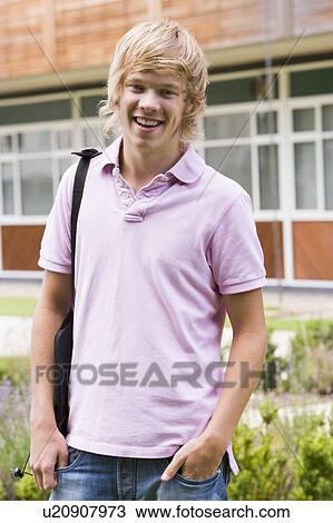 Stock Image - Student standing outdoors smiling. Fotosearch