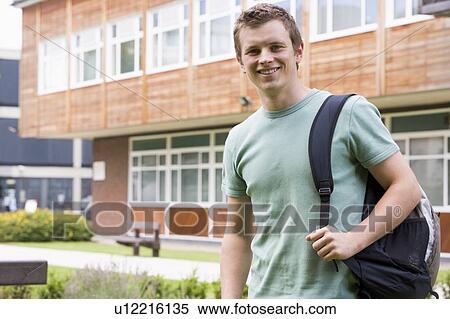 Stock Photography - Student standing outdoors smiling. Fotosearch