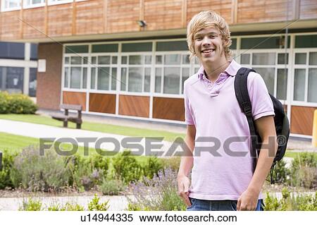 Stock Photography - Student standing outdoors smiling. Fotosearch