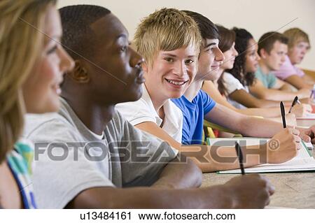 Stock Image - Students in class paying attention and taking notes (selective focus). Fotosearch