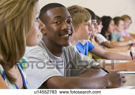Stock Image - Students in class paying attention and taking notes (selective focus). Fotosearch