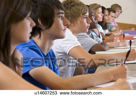 Stock Image - Students in class paying attention and taking notes (selective focus). Fotosearch