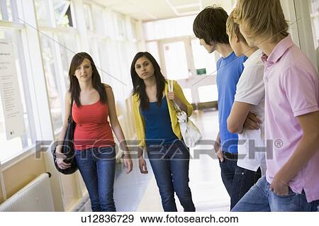 Students in corridor watching other students walking by (selective focus) View Large Photo Image Stock Photo - Students in corridor watching other students walking by (selective focus). Fotosearch