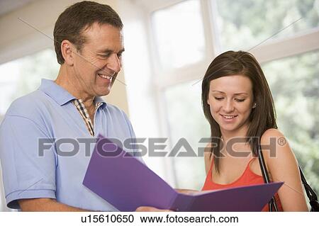Teacher in corridor talking to student with notebooks View Large Photo Image Stock Image - Teacher in corridor talking to student with notebooks. Fotosearch