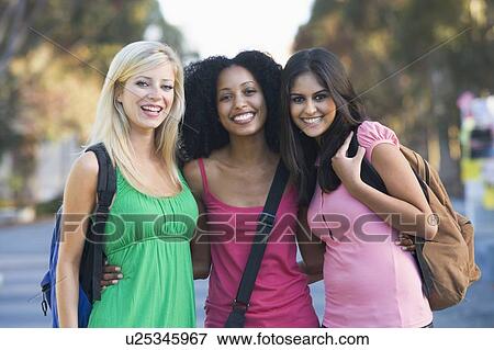 Three women outdoors standing with arms around each other (selective focus) View Large Photo Image Stock Photo - Three women outdoors standing with arms around each other (selective focus). Fotosearch