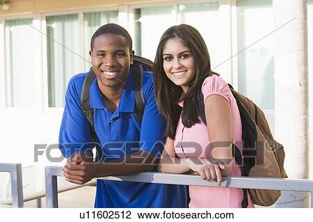 Two people standing on balcony leaning on railing View Large Photo Image Stock Image - Two people standing on balcony leaning on railing. Fotosearch