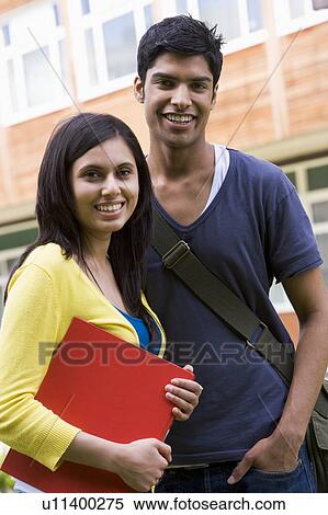 Stock Photography - Two students standing outdoors smiling. Fotosearch