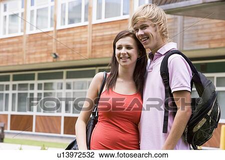 Two students standing outdoors with arms around waists smiling View Large Photo Image Stock Image - Two students standing outdoors with arms around waists smiling. Fotosearch