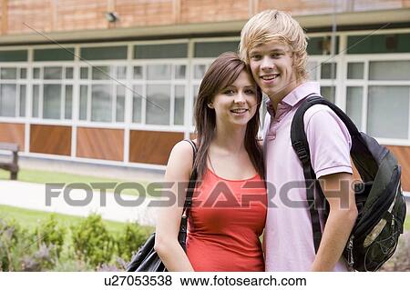 Two students standing outdoors with arms around waists smiling View Large Photo Image Stock Photo - Two students standing outdoors with arms around waists smiling. Fotosearch