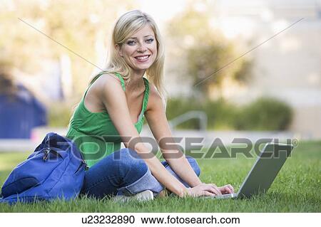 Woman outdoors sitting on grass with laptop (selective focus) View Large Photo Image Stock Image - Woman outdoors sitting on grass with laptop (selective focus). Fotosearch
