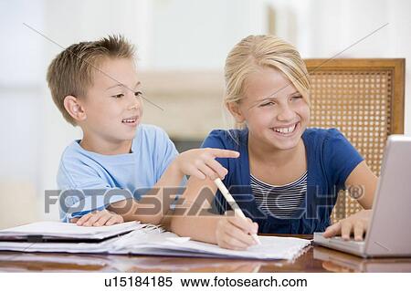 Stock Photography - Boy Pointing At Big Sisters Homework On Laptop. Fotosearch