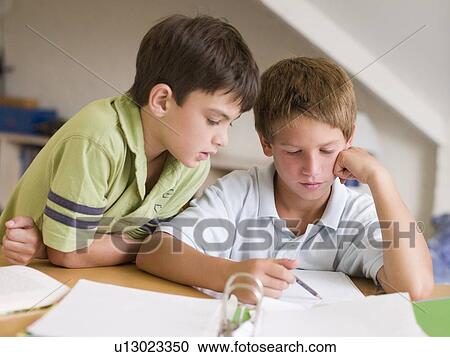 Stock Image - Two Young Boys Doing Their Homework Together. Fotosearch