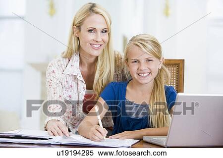 Woman helping young girl with laptop do homework in dining room View Large Photo Image Stock Photography - Woman helping young girl with laptop do homework in dining room. Fotosearch