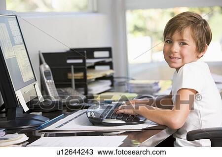 Young boy in home office with computer smiling View Large Photo Image Stock Image - Young boy in home office with computer smiling. Fotosearch