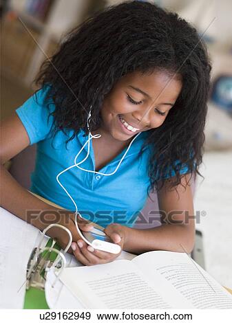 Young Girl Distracted From Her Homework, Playing With An MP3 Player View Large Photo Image Stock Photo - Young Girl Distracted From Her Homework, Playing With An MP3 Player. Fotosearch