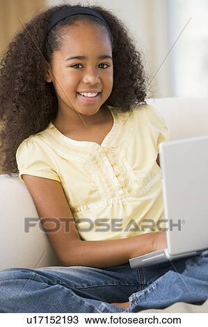Young Girl Sitting On A Sofa, Using A Laptop View Large Photo Image Stock Image - Young Girl Sitting On A Sofa, Using A Laptop. Fotosearch