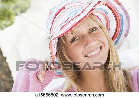 Stock Image - Blonde woman in a pink sweater posing outdoors. Fotosearch