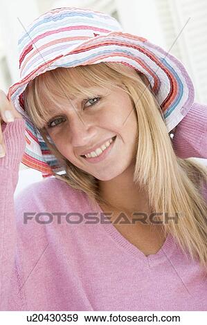 Stock Photo - Blonde woman in a pink sweater posing outdoors. Fotosearch