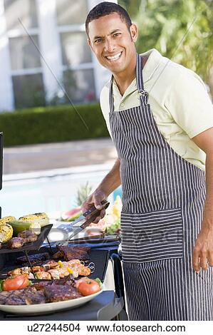 Picture - Man Barbequing In A Garden. Fotosearch
